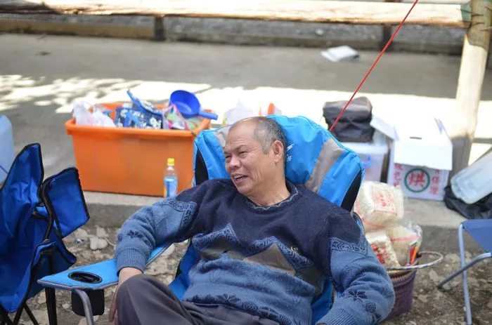 爸爸則是慵懶地躺在椅子上，享受好天氣