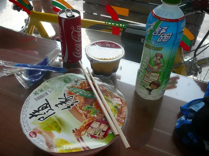 該吃的還是不能少！到小七吃吧！老闆～素食泡麵+可樂+布丁+運動飲料我會不會吃太多了.........？
